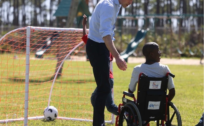 prince william with a young boy in a wheelchair